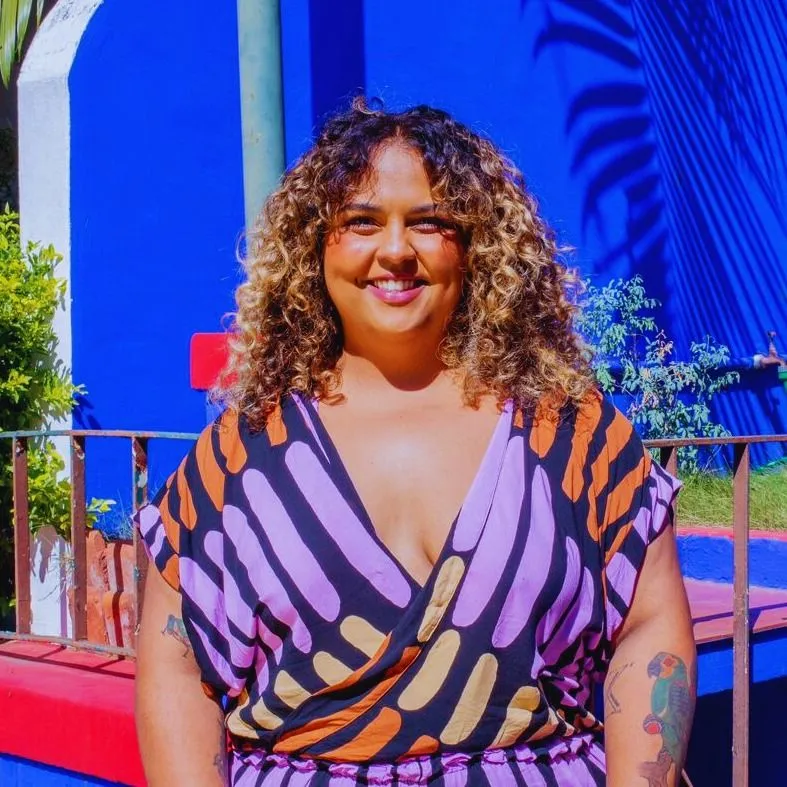 Retrato de Marina Araujo diante de parede azul